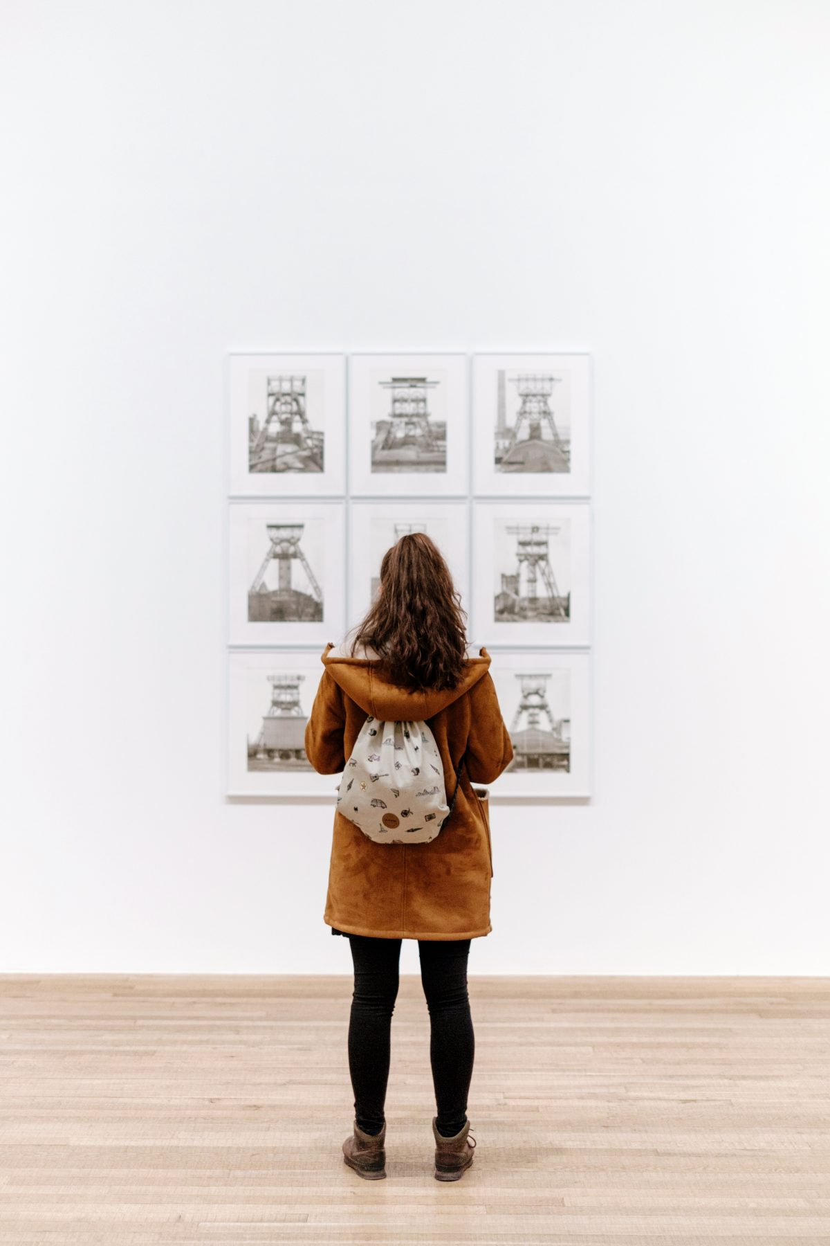 A woman wearing a brown hoodie admiring art pieces in front of her at the Cleveland Museum of Art
