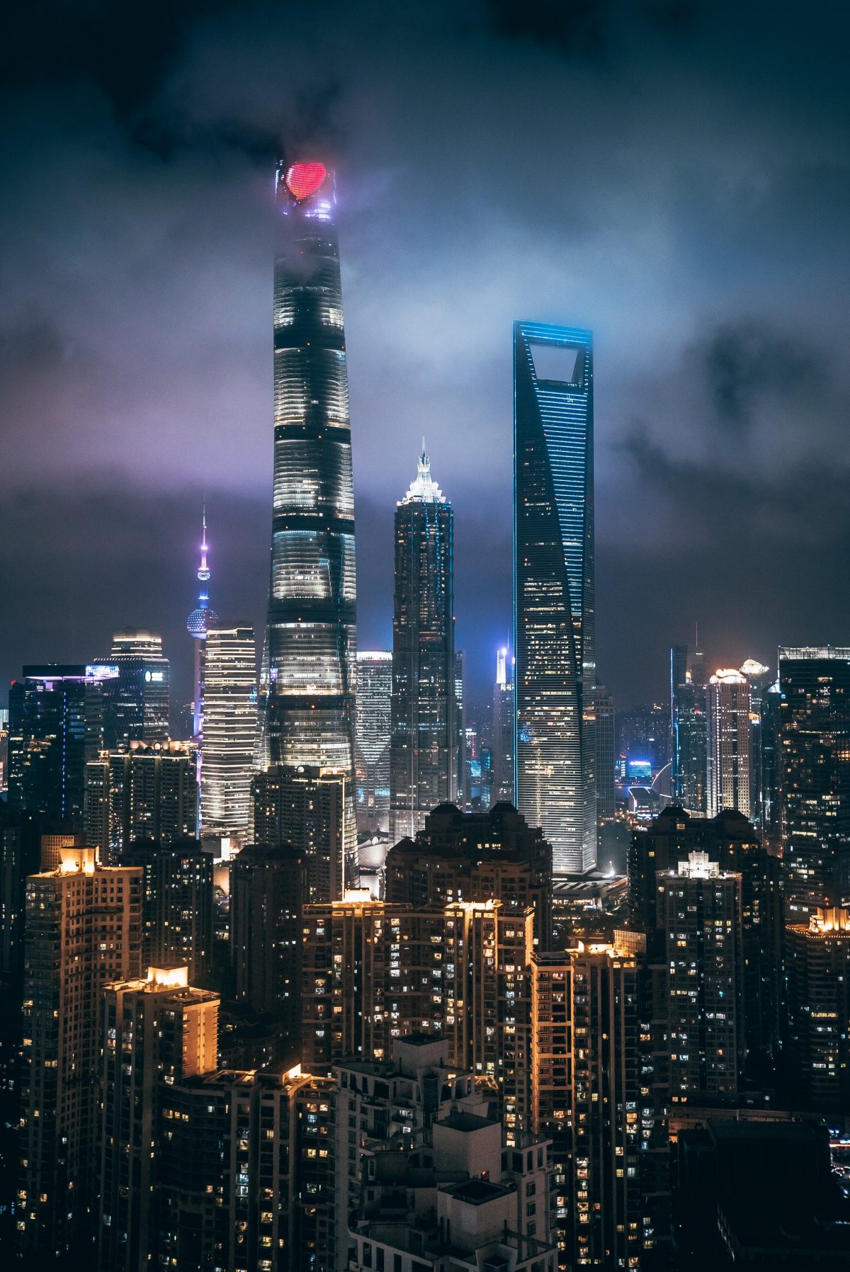 The world’s first skyscraper trio towering over other buildings in Shanghai with the night skyline in the background The world’s first skyscraper trio towering over other buildings in Shanghai with the night skyline in the background