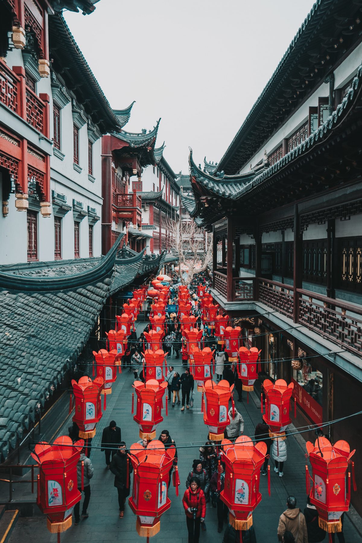 Bright red lanterns that adorn the streets of Yu Garden as pedestrians walk by admiring the classic oriental architecture Bright red lanterns that adorn the streets of Yu Garden as pedestrians walk by admiring the classic oriental architecture