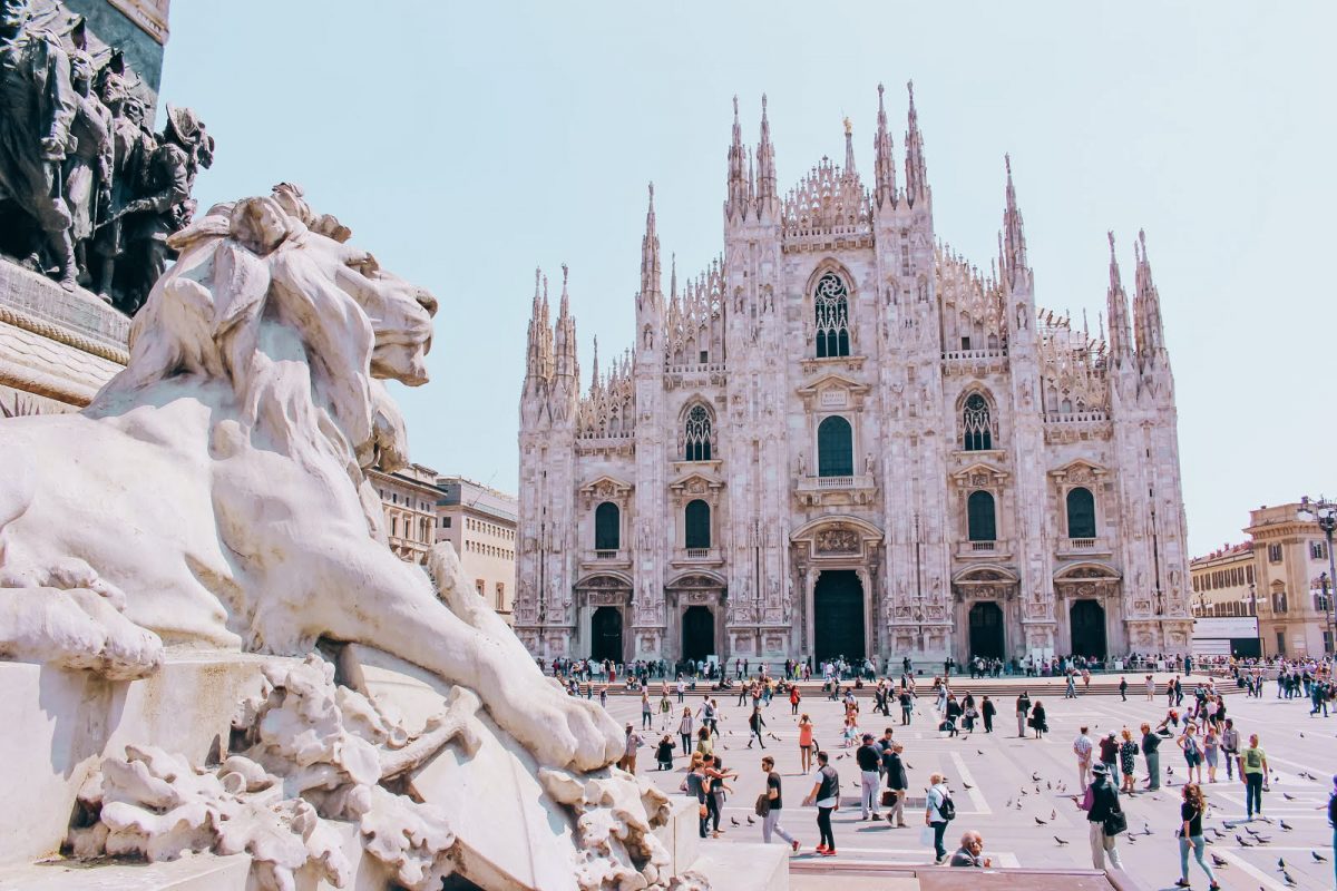 two marble lions roaring and Duomo at Milan square Piazza del Duomo