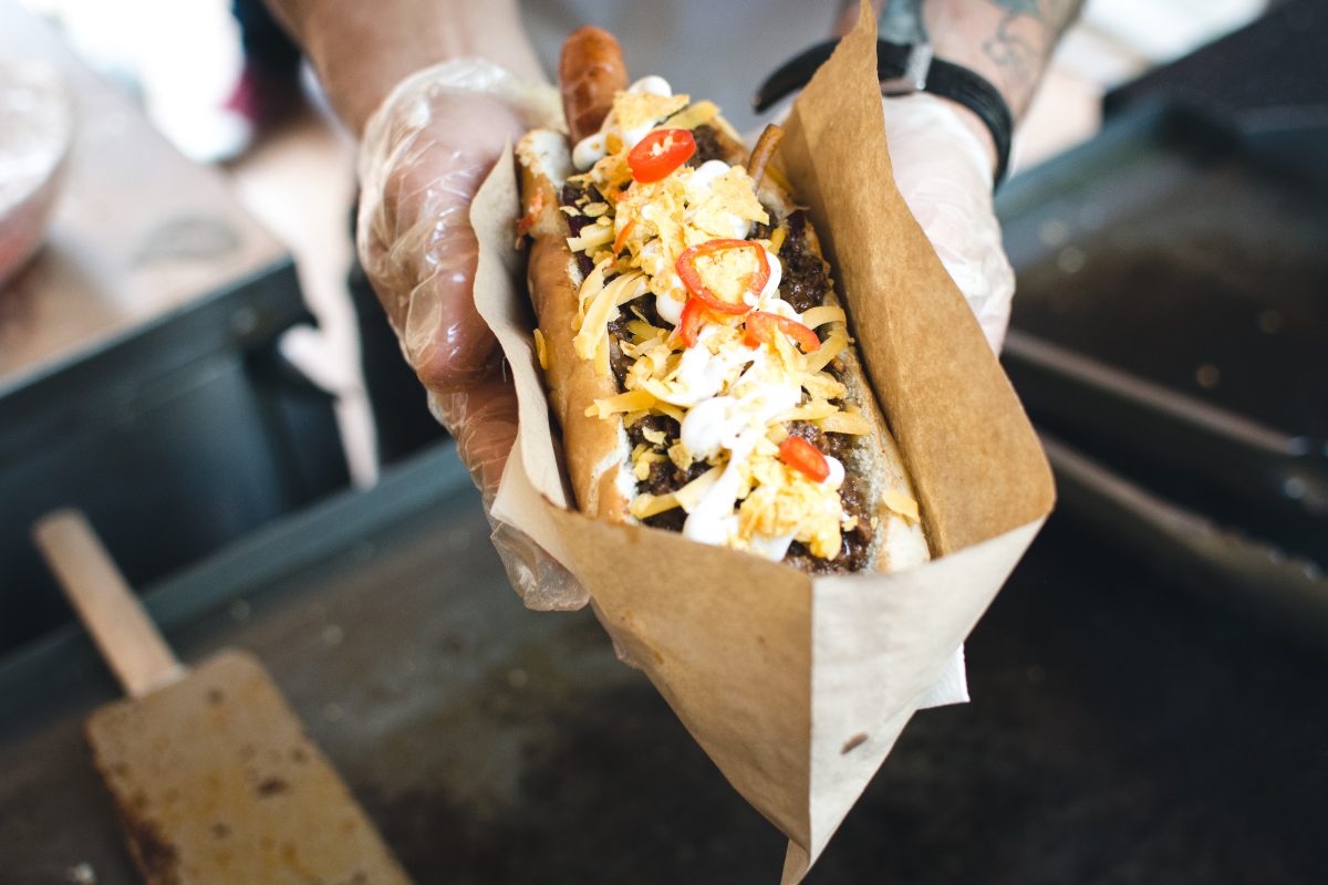 Purchasing tasty hot dog at street market