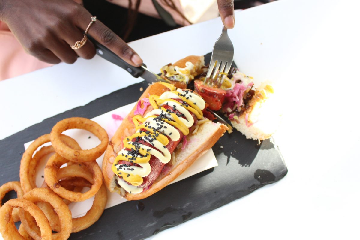 Woman eating Hot Dog with onion rings