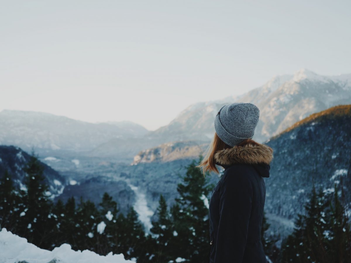 Women standing on the mountain with a beanie cap Women standing on the mountain with a beanie cap