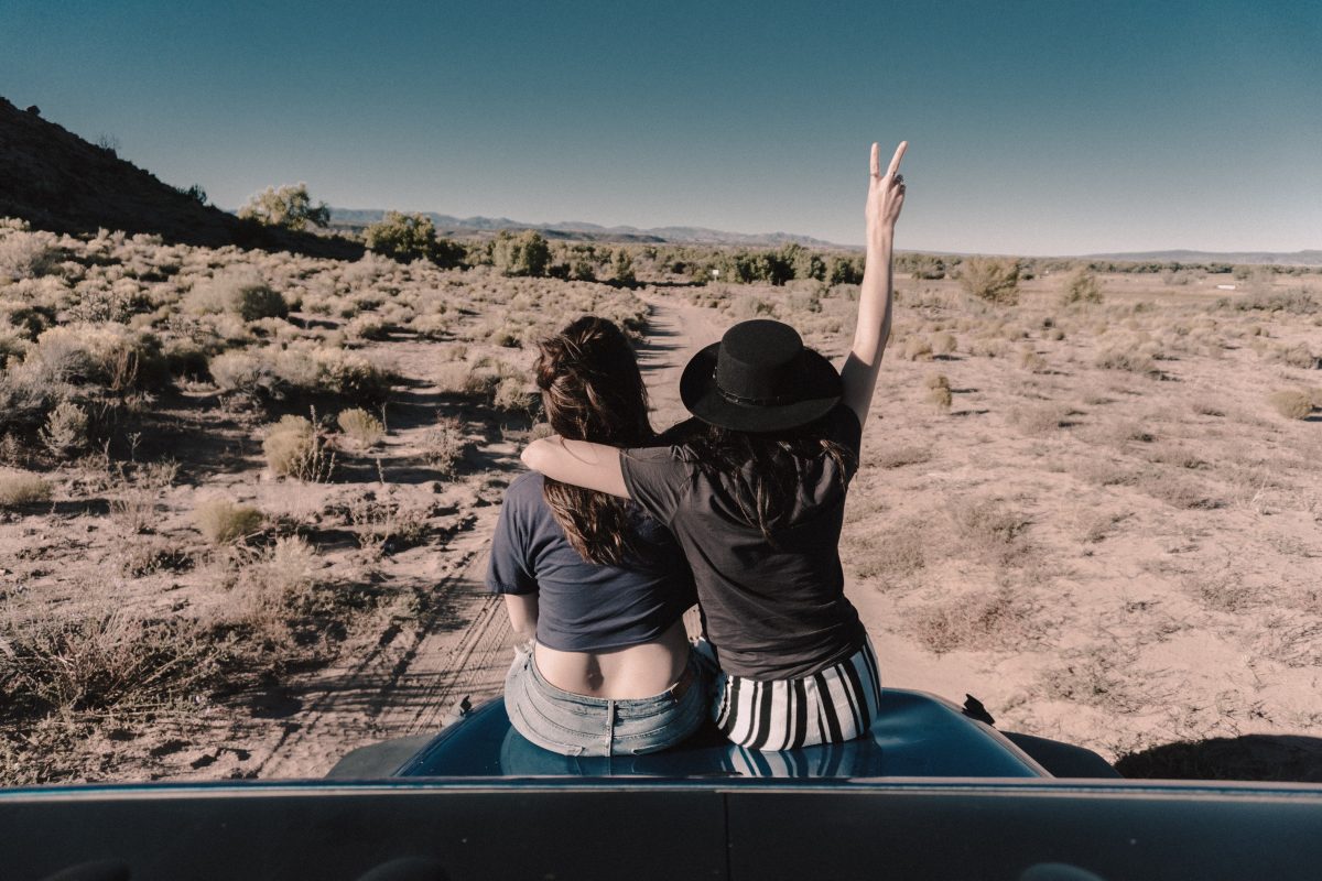 Two friends sitting on the top of an RV Two friends sitting on the top of an RV