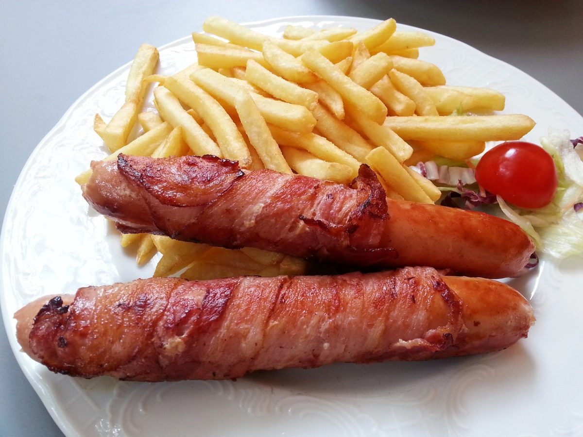 Sausages and chips on a white plate