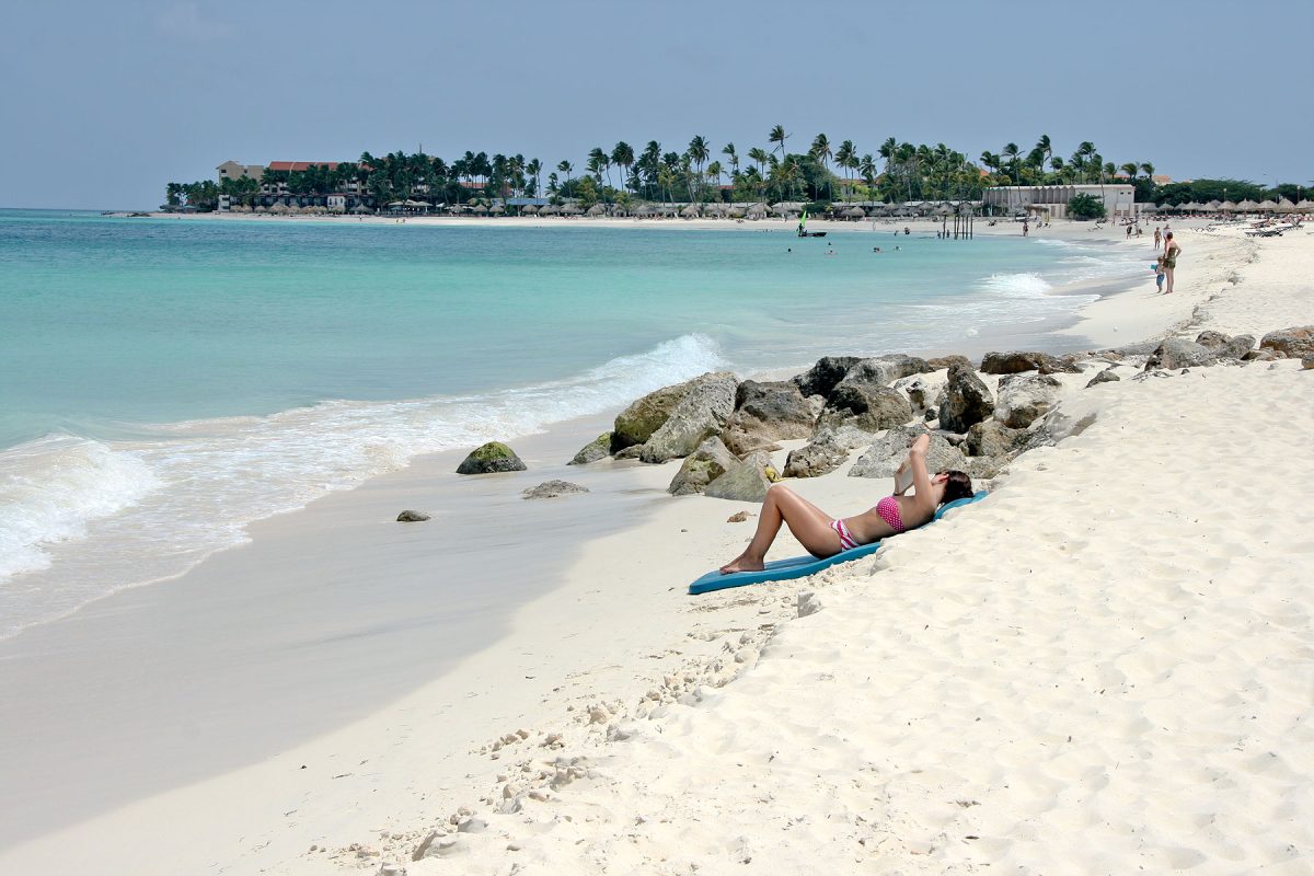 Woman relaxing on Eagle Beach in Aruba