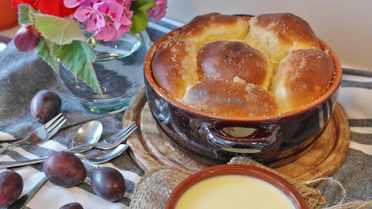 Buchteln in a dish with forks and spoon on  a table