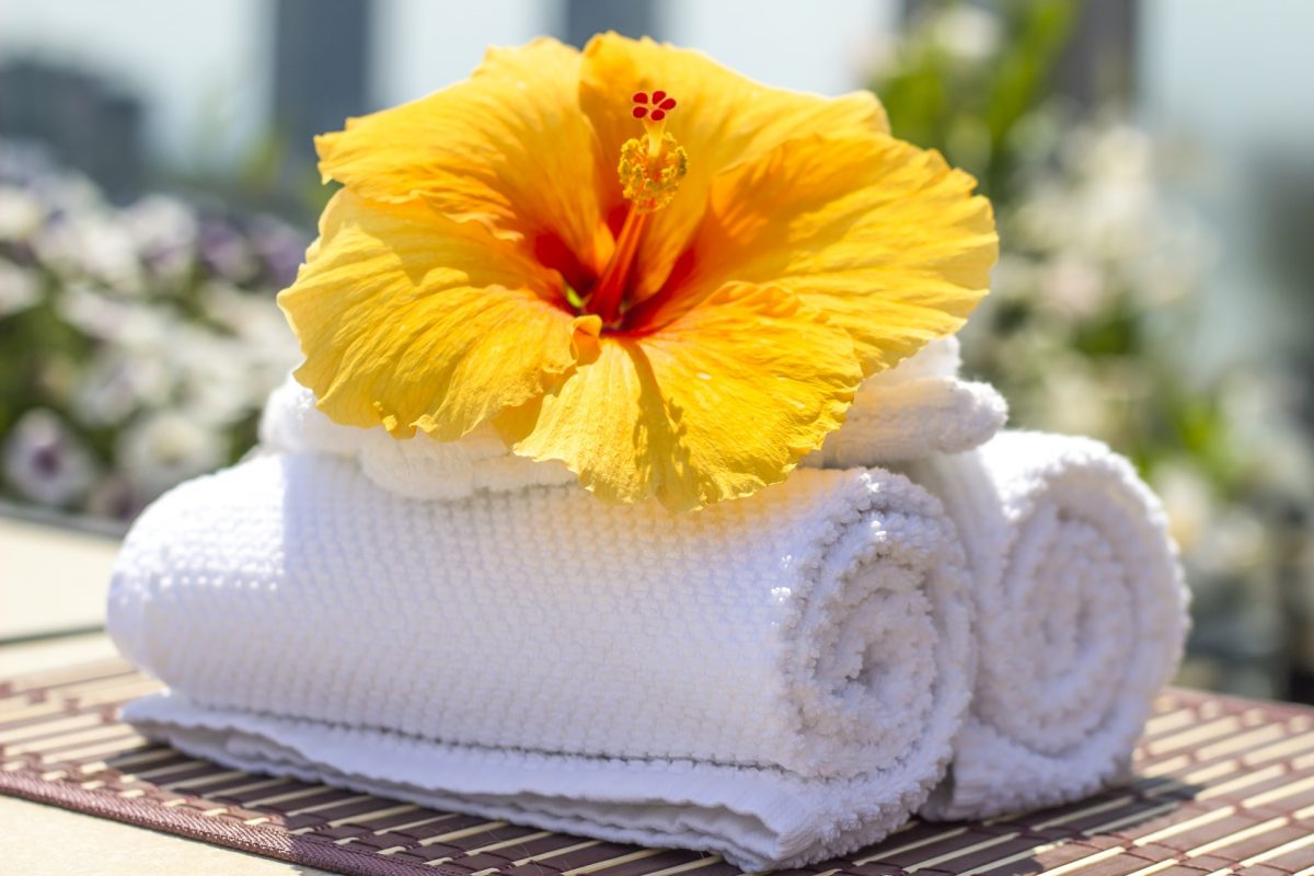 stack of white towels with a yellow flower on top