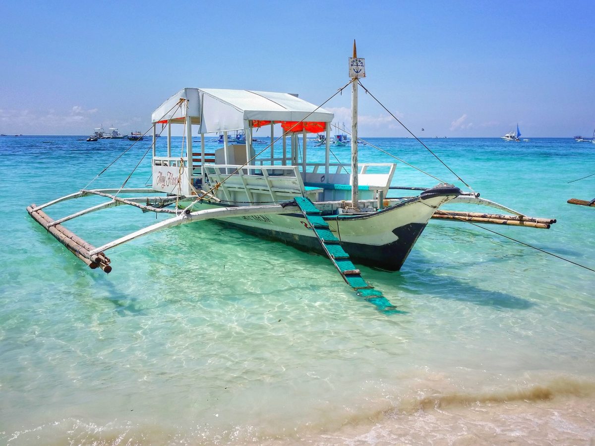 A boat docks on a beach in Boracay, Philippines