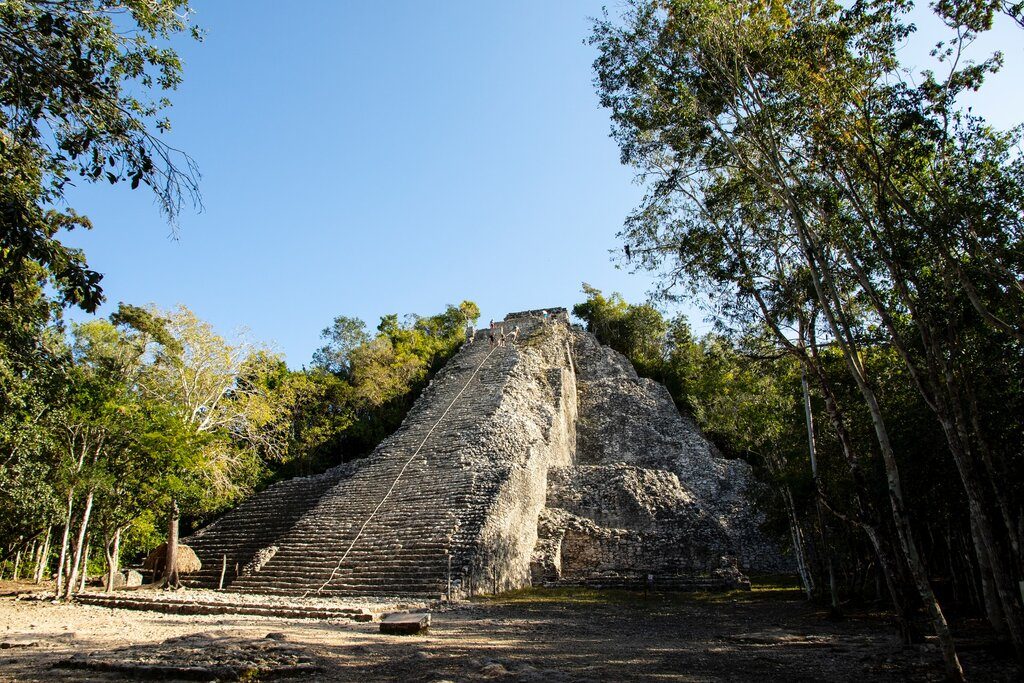 People climbing to the top of a pyramid at Coba ruins.