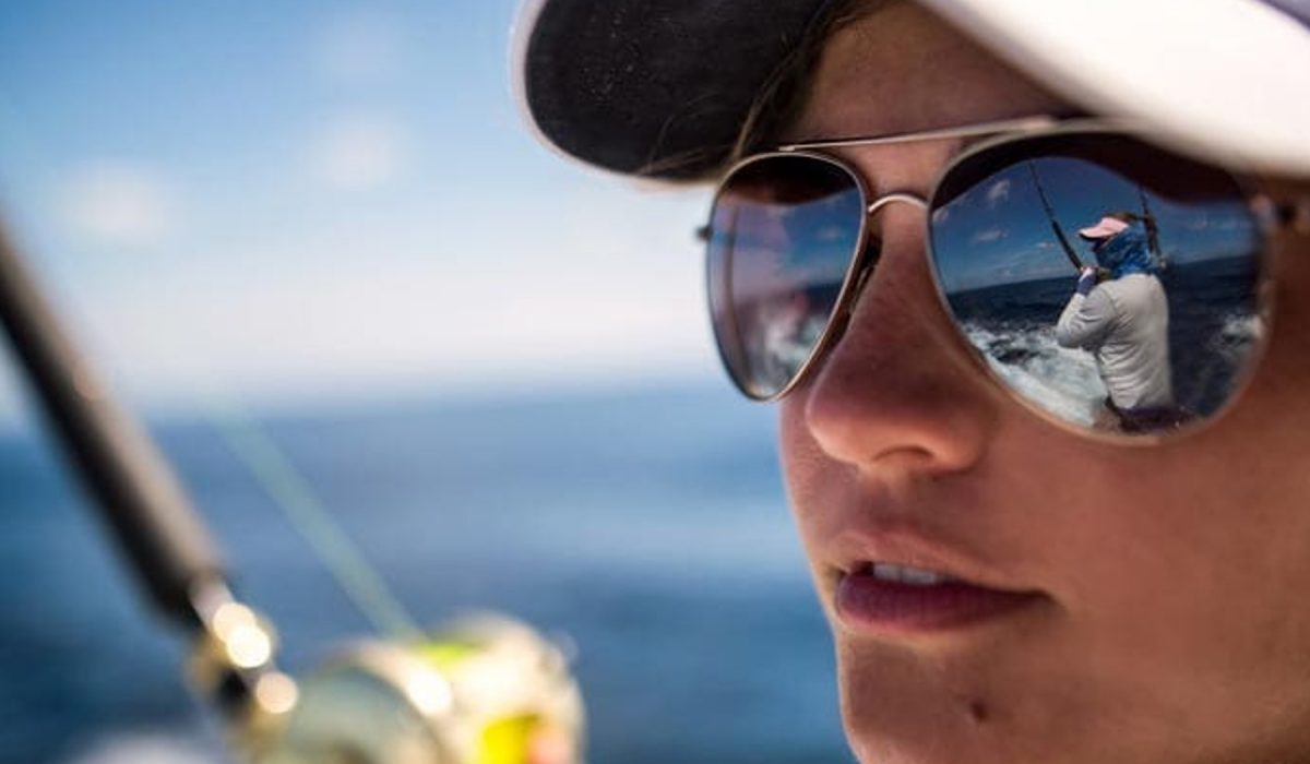costa sunglasses Woman wearing Costa sunglasses with another woman fishing reflected in the lens.