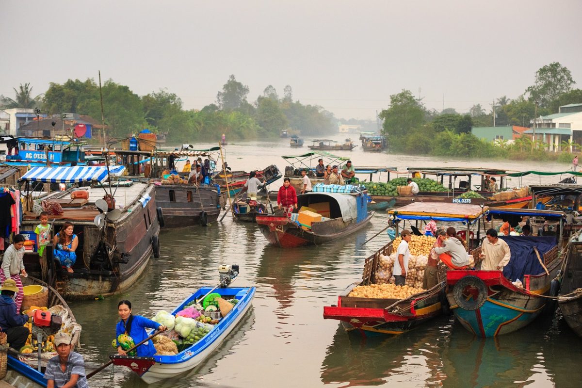 River in Thailand full of floating market boats and stilt houses