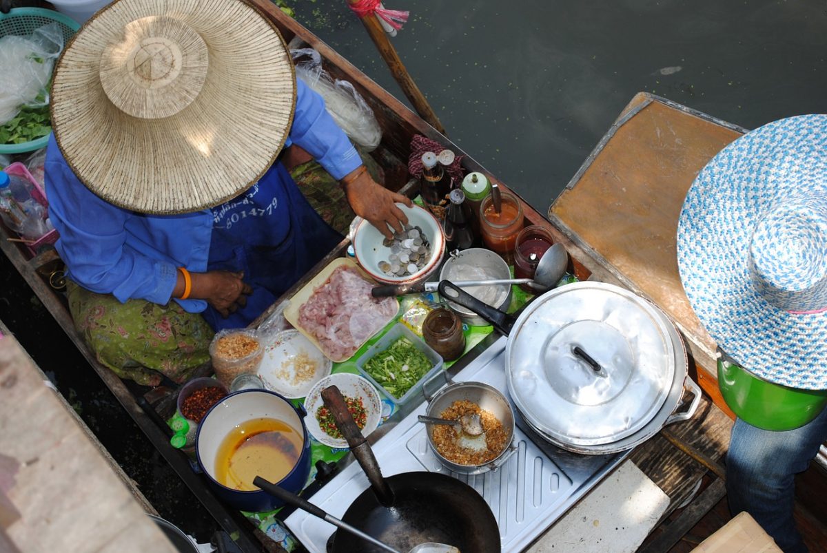 Food merchant preparing hot food on a floating boat