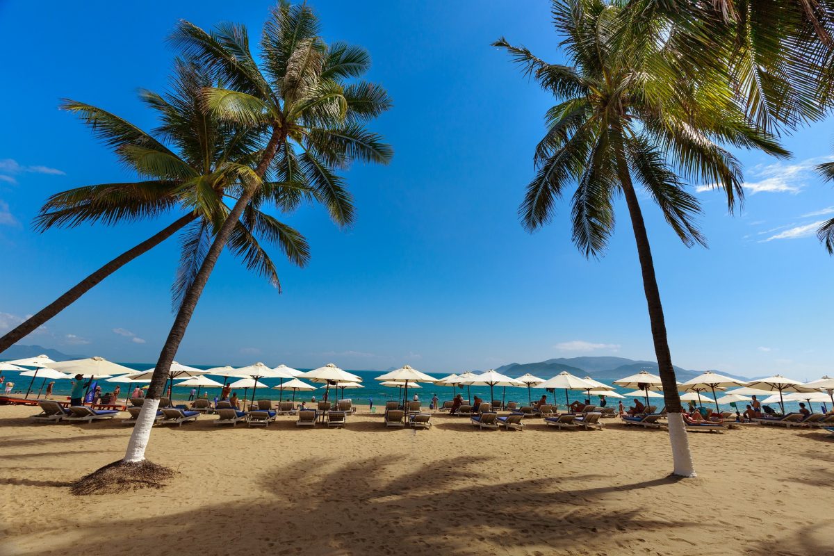 Visitors relax on beachside lounge chairs on Nha Trang Beach, Nha Trang, Vietnam