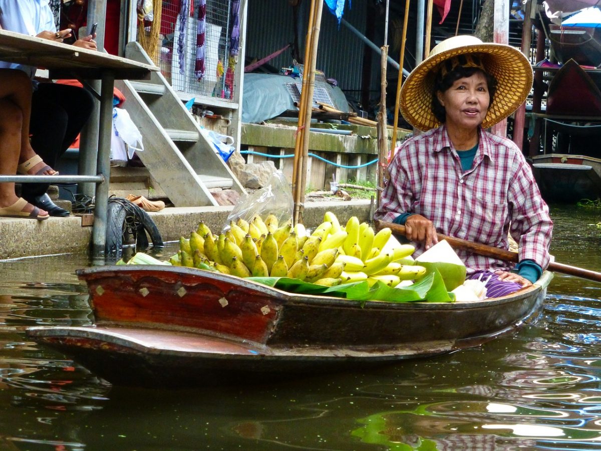 Lady in a floating boat selling bananas