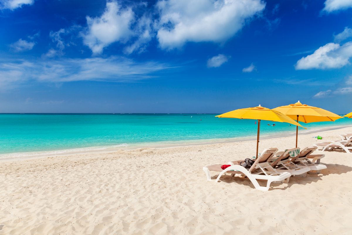 Vivid blues and turquoise with white sands, Grace Bay Beach, Turks & Caicos. Bright yellow beach umbrellas make a great contrast color