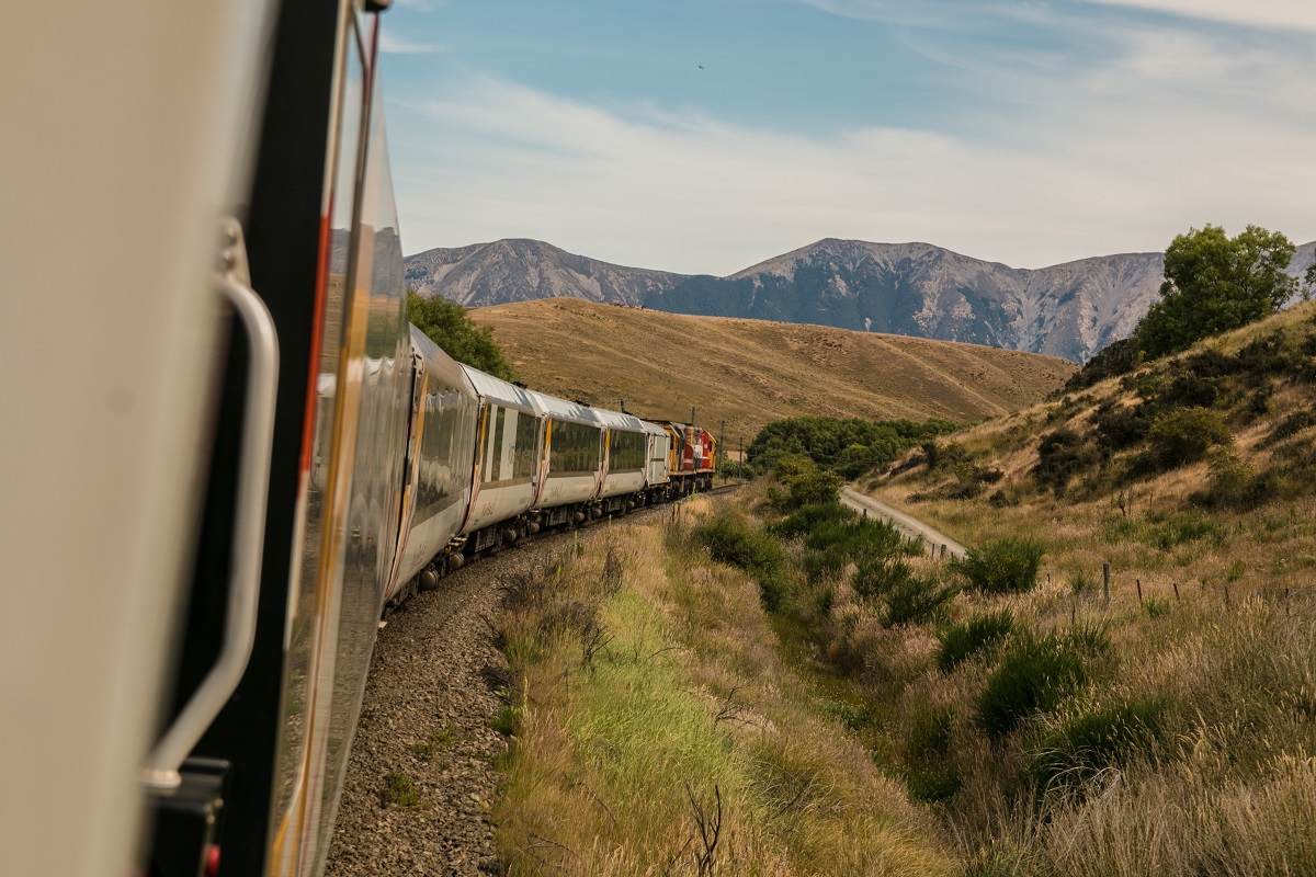 White train with the distance of mountain during daytime