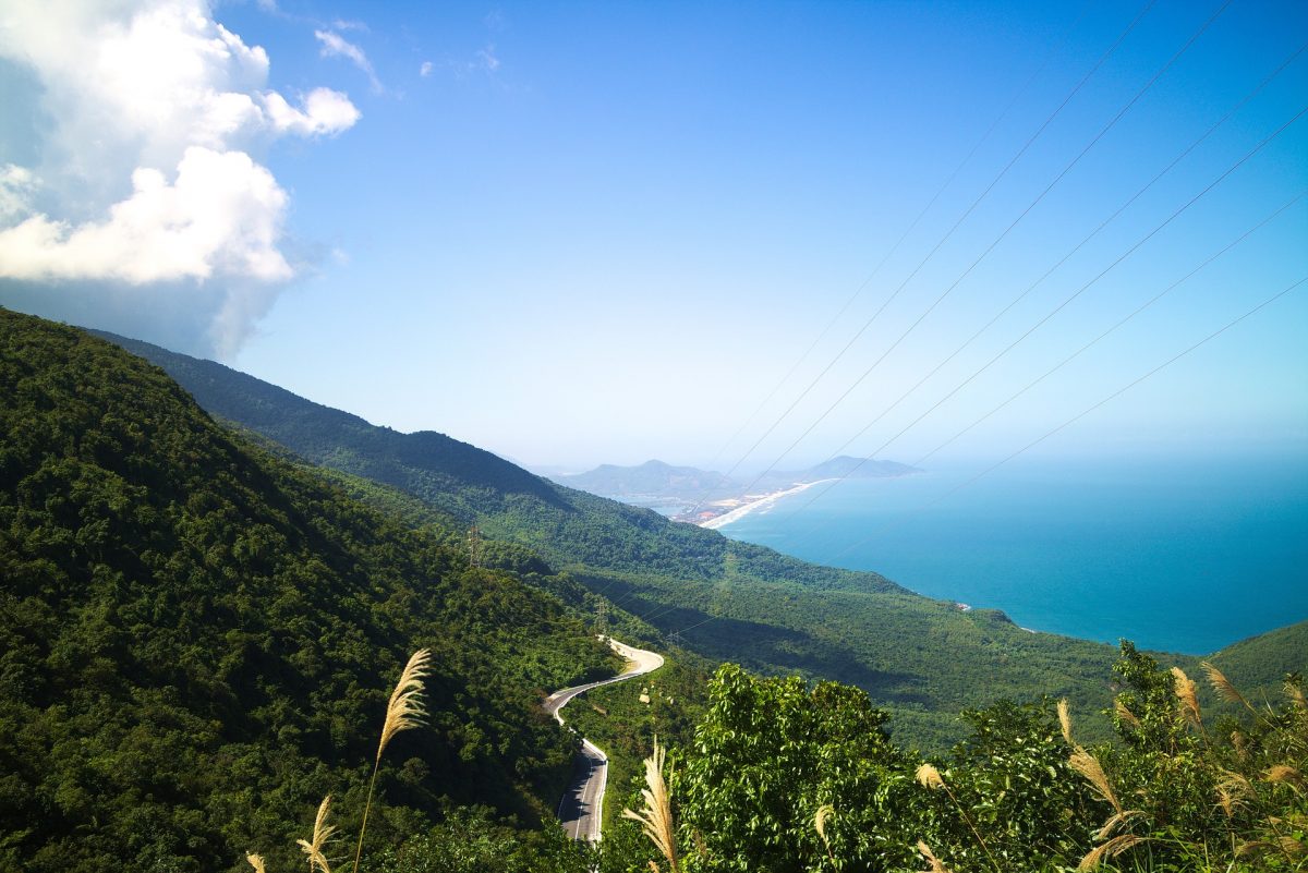 A long winding road (Hai Van Pass) runs up a mountain