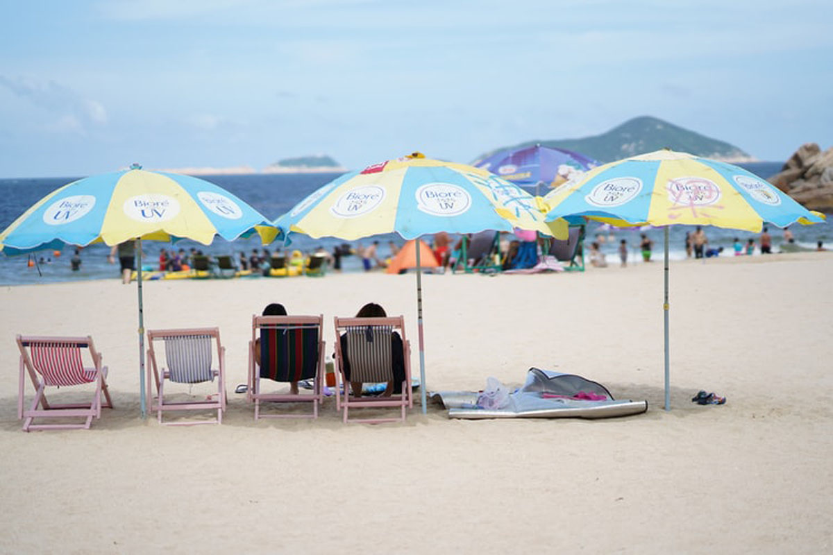 travelers relaxing on the beach under the beach umbrellas