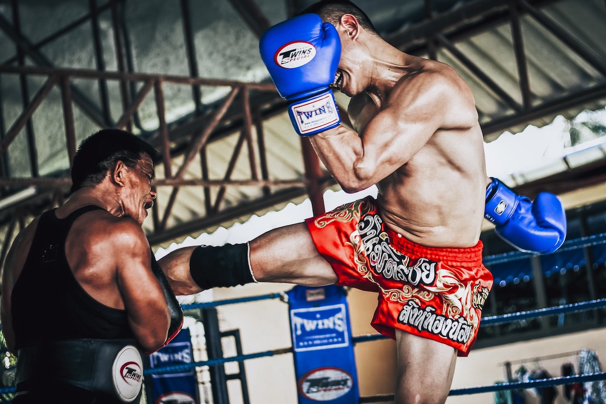 two people having a muay thai fight in the ring