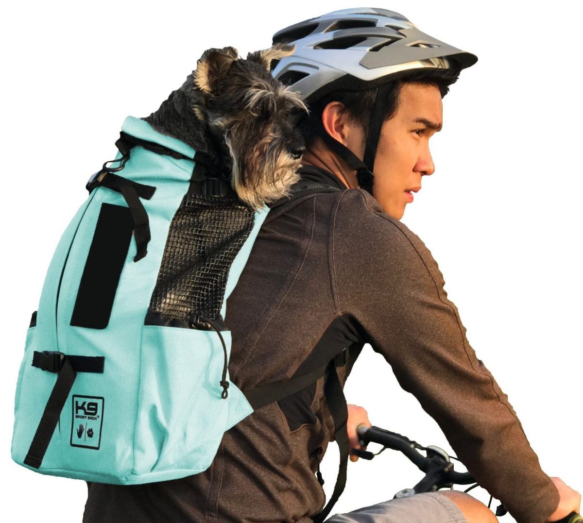 Photo of the K9 Sport Sack AIR in mint green carrying a black Terrier on a cyclist’s back who is wearing a grey helmet, a brown long-sleeved top, and grey shorts on a bicycle Photo of the K9 Sport Sack AIR in mint green carrying a black Terrier on a cyclist’s back who is wearing a grey helmet, a brown long-sleeved top, and grey shorts on a bicycle