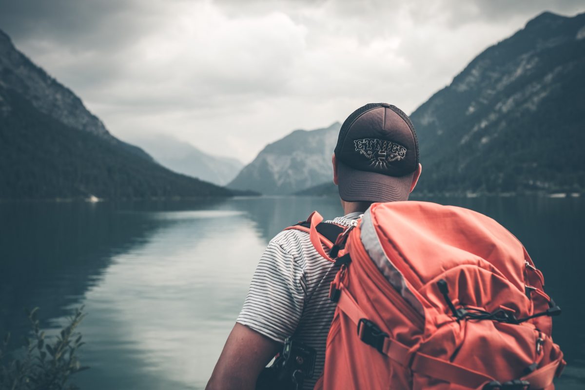 A lonely backpacker with a red backpack 