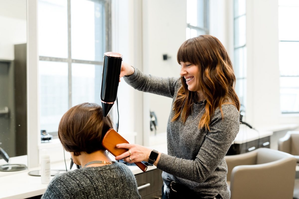 Hairdresser drying women's hair in a Salon in Spain