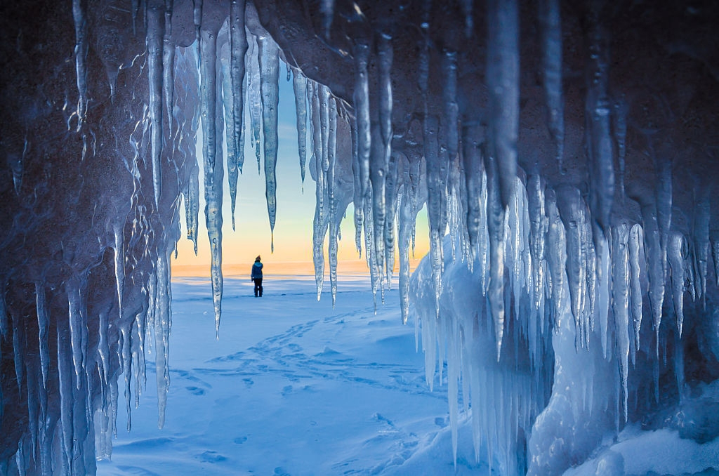 Women waiting for Northern Lights near an ice cave in Lake Superior Michigan during the winter 
