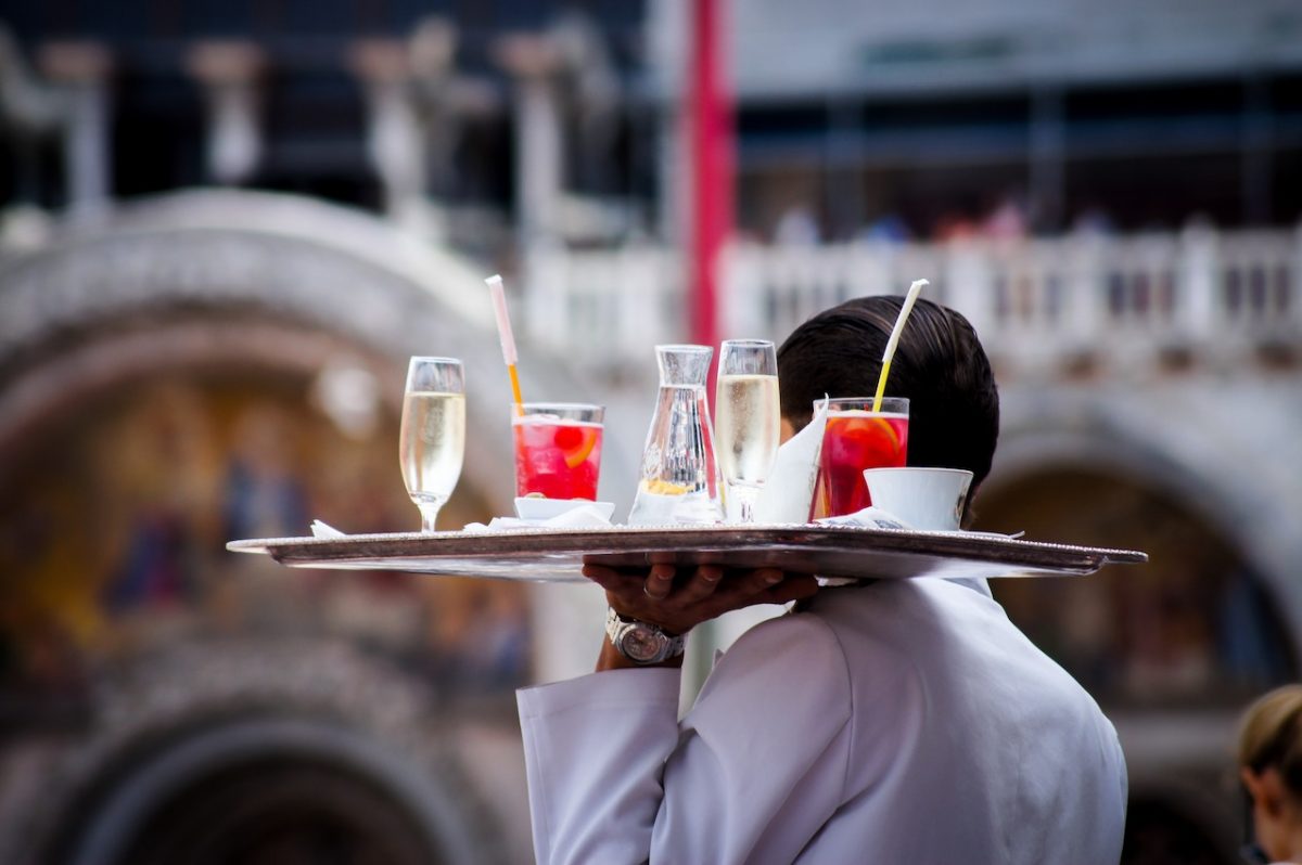 Restaurant server holding up the tray of drinks