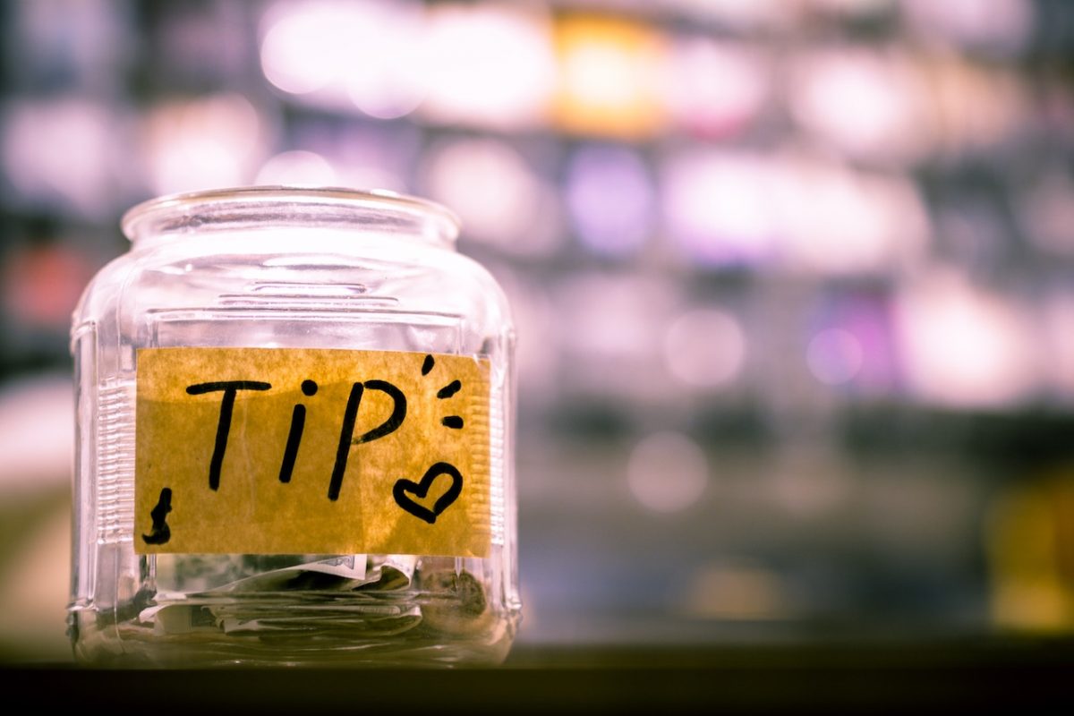 Tipping jar with coins and bank notes 