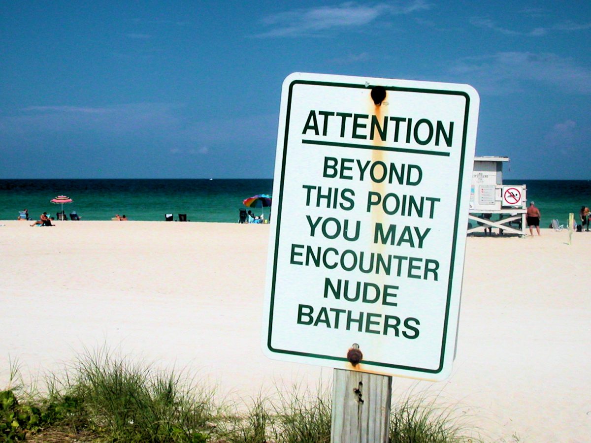 a sign warning people about nude bathers in the area