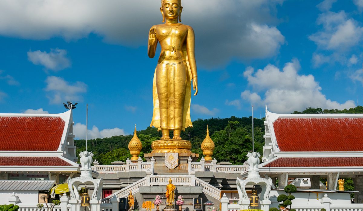 Golden standing Buddha at the peak at Hat Yai Municipality