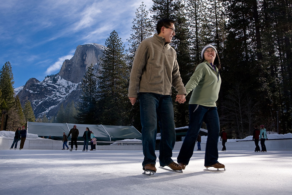 Couple holding hands while ice skating at Curry Village Ice Skating Rink