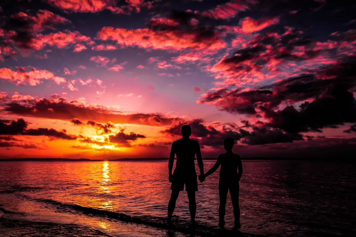 Silhouette of Couple while holding hands on a sunset background