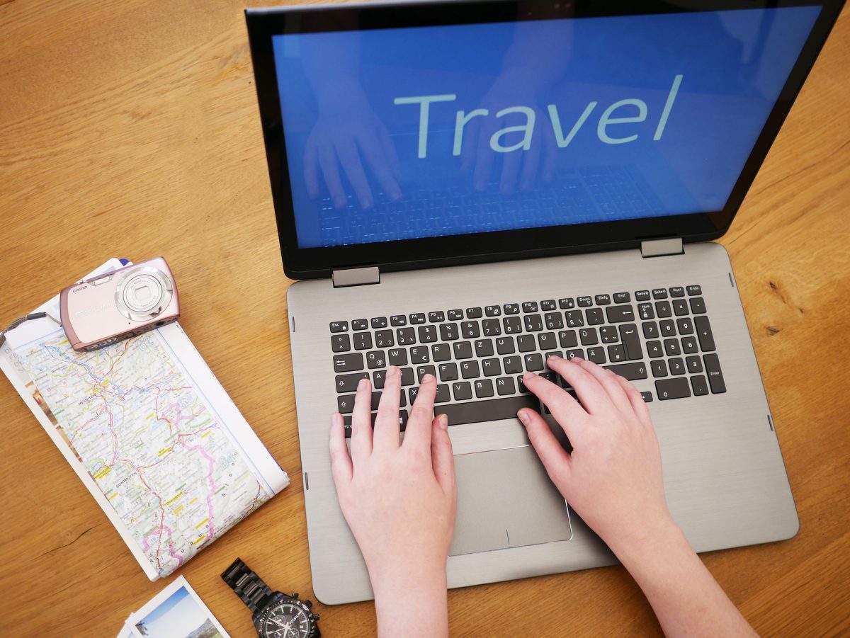 Someone using a laptop with Travel words on screen