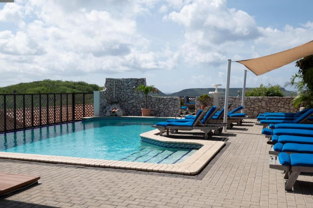 View of the pool and lounge chairs on a balcony at The Natural Curacao