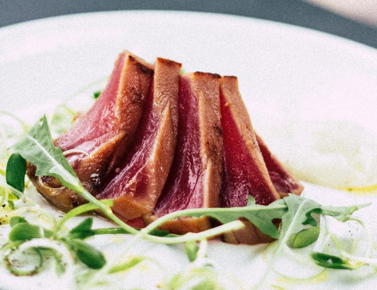 Rare grilled lamb fillet on a plate with alfafa vegetables