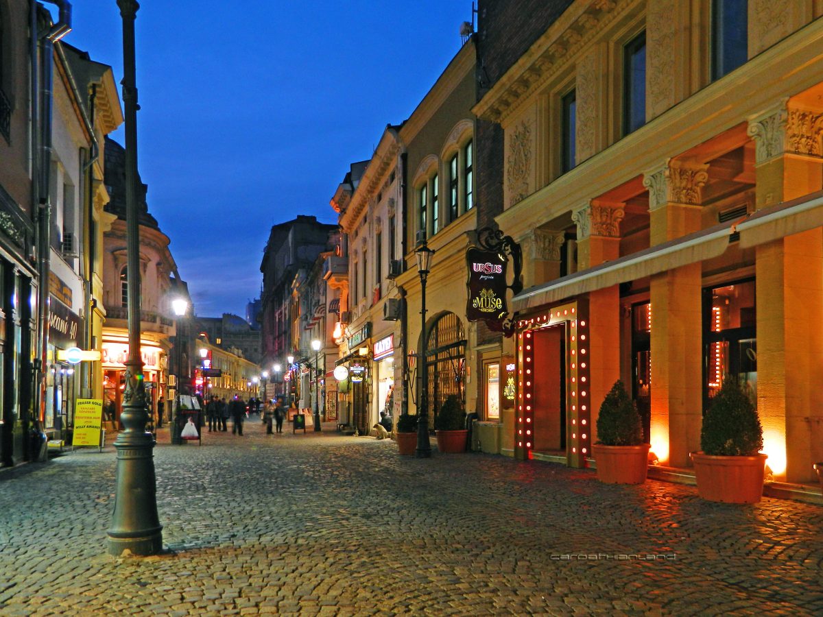 Whitewashed buildings illuminated by street lights at evening