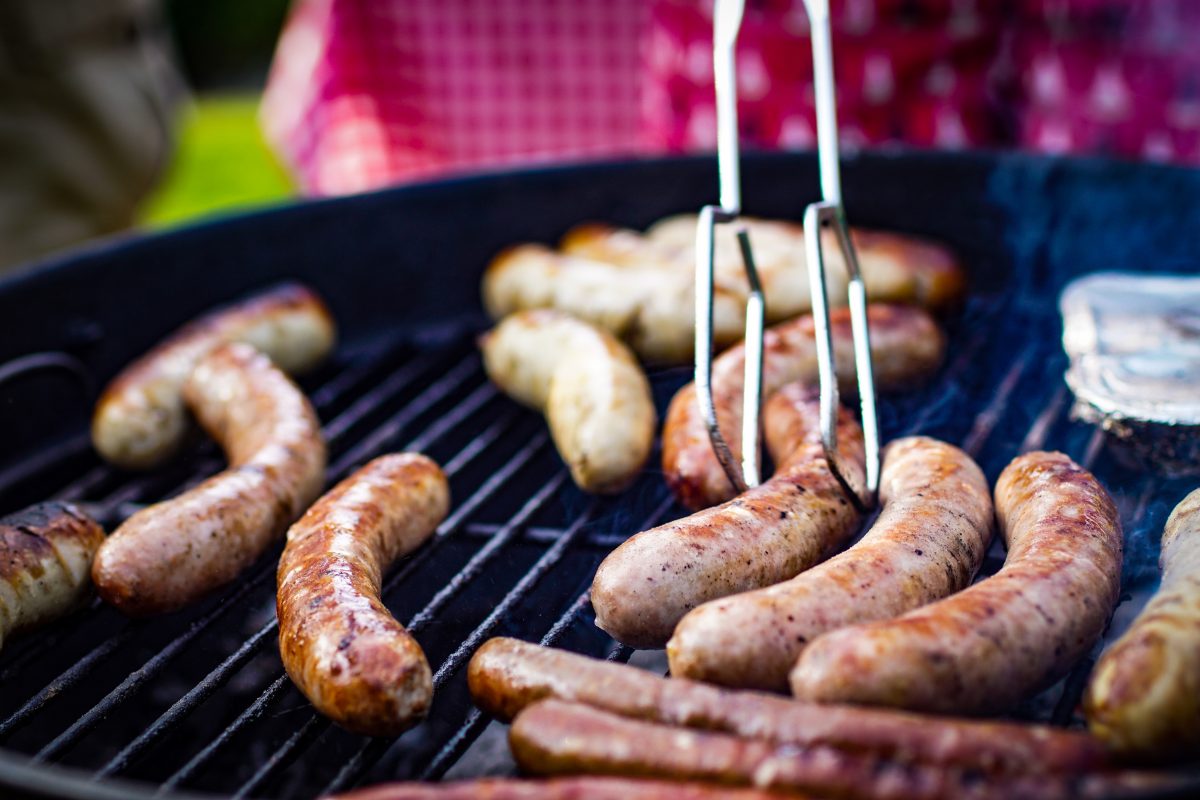 Sausages grilling on a BBQ plate