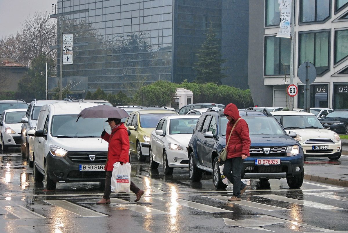 People Crossing Pedestrian Lane While Raining