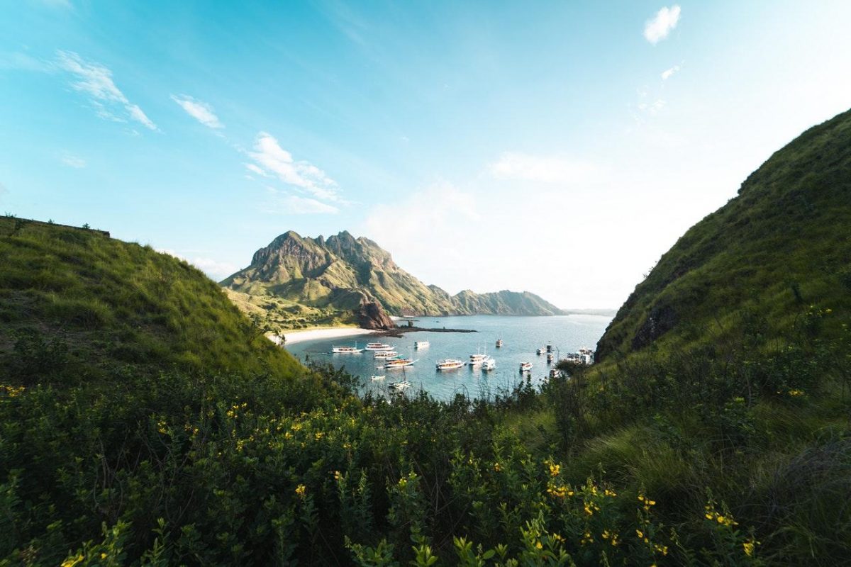 photo of green, lush mountains overlooking the boats on the beach photo of green, lush mountains overlooking the boats on the beach