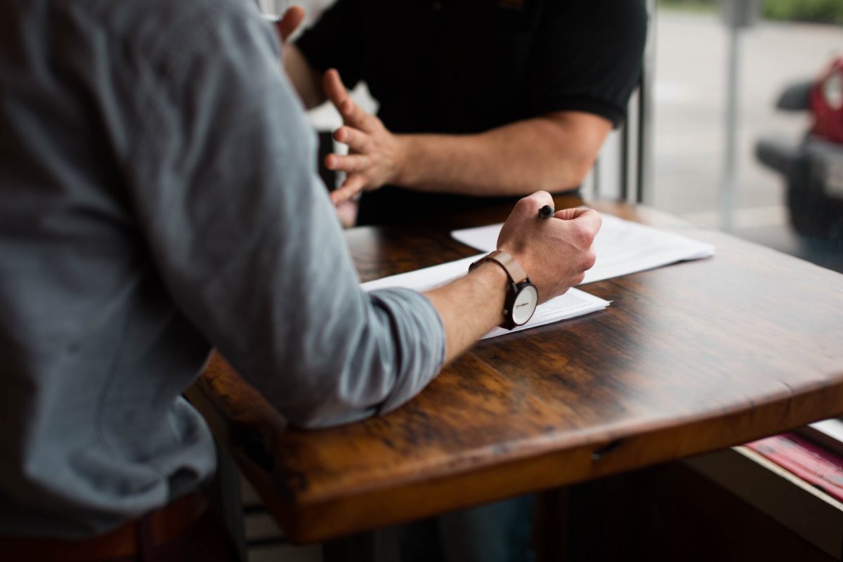 Photo of two men discussing while seated across each other