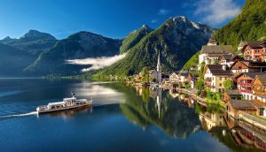 A boat cruises along the stunning Hallstatt Lake in Austria