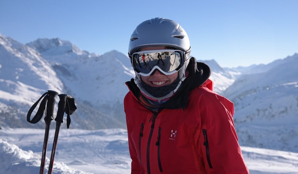 A skier wearing a ski goggle over helmer poses for the camera A skier wearing a ski goggle over helmer poses for the camera