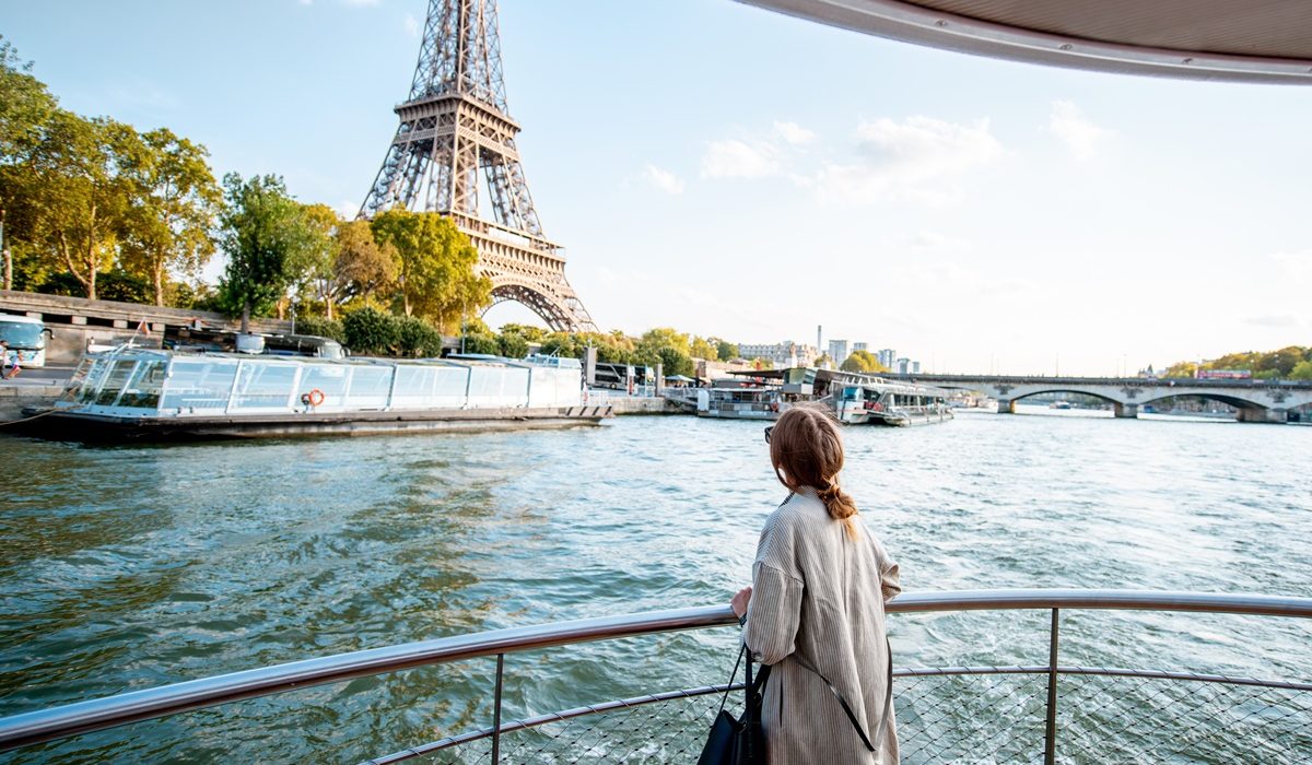 Young woman enjoying beautiful landscape view on the Seine overlooking Eiffel Tower