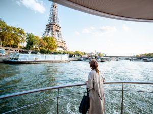 Young woman enjoying beautiful landscape view on the Seine overlooking Eiffel Tower
