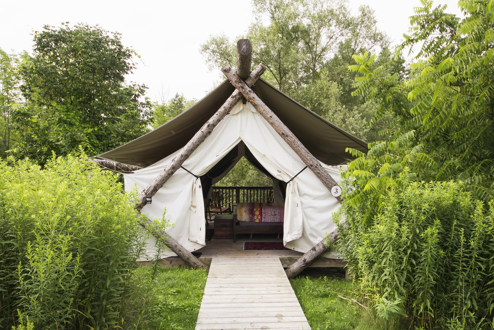 Firelight Camps - Photo from Firelight Camps' website Glamping tent with tree beams and white canvas sheets as cover