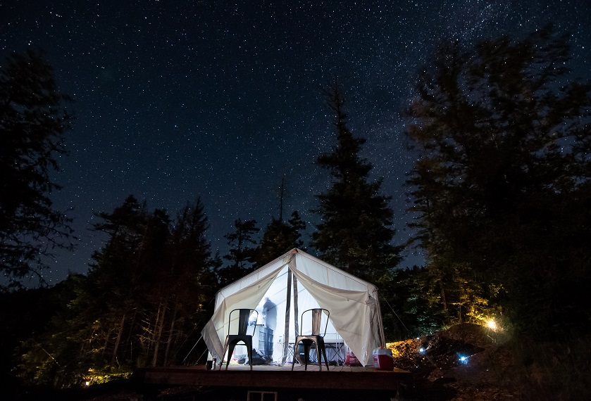 Glamping tent lit up against the dark outdoors