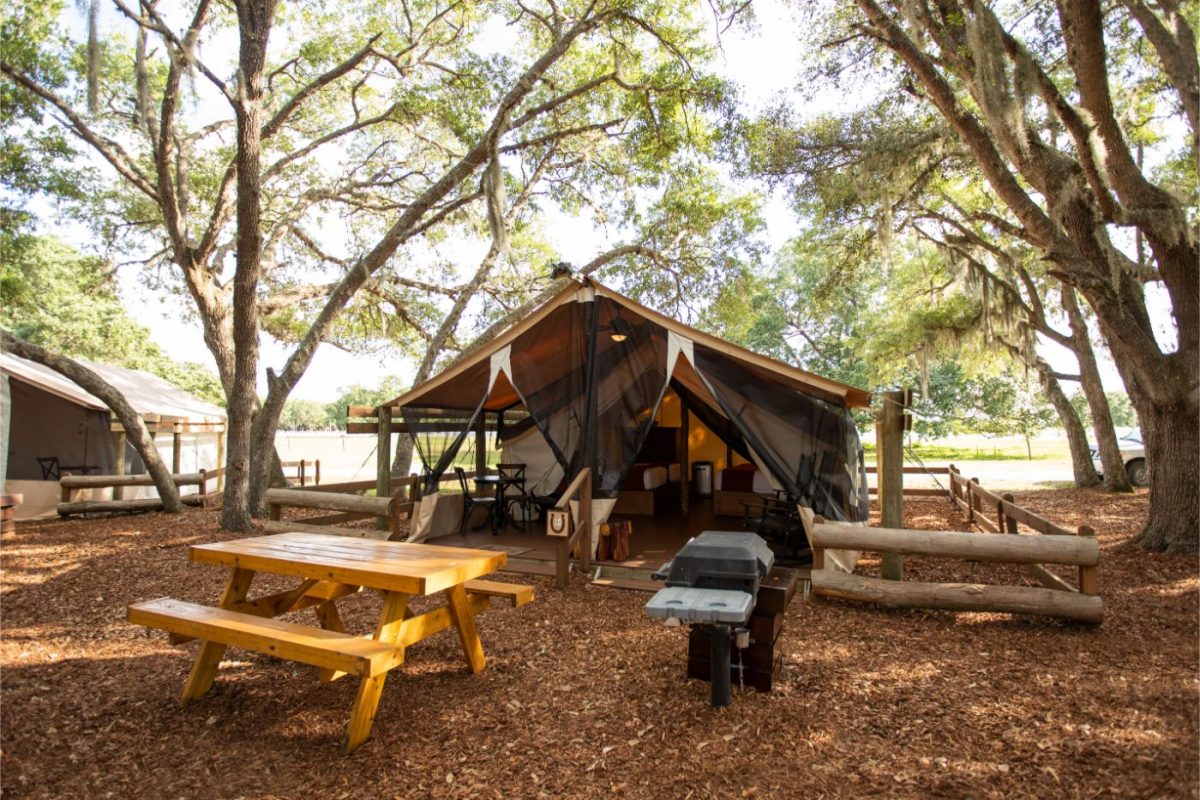 Picnic tables set up in front of Westgate River Ranch's glamping tents