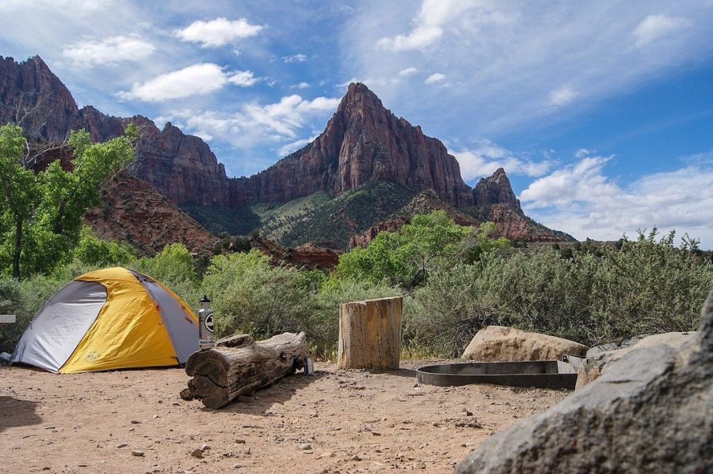 Yellow tent pitched on a mountain cliff